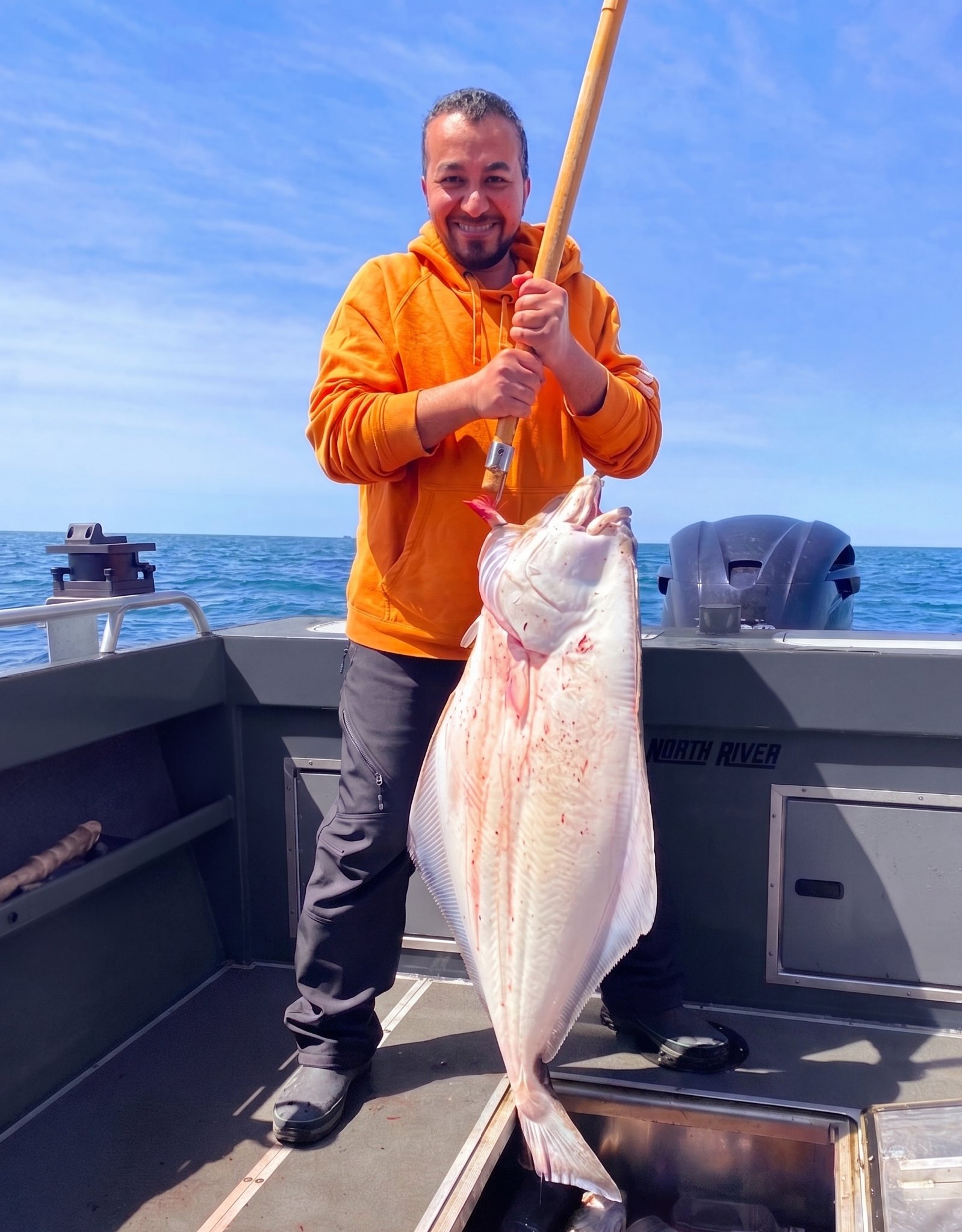 Daniel holding a large halibut on a North River boat in Washington State